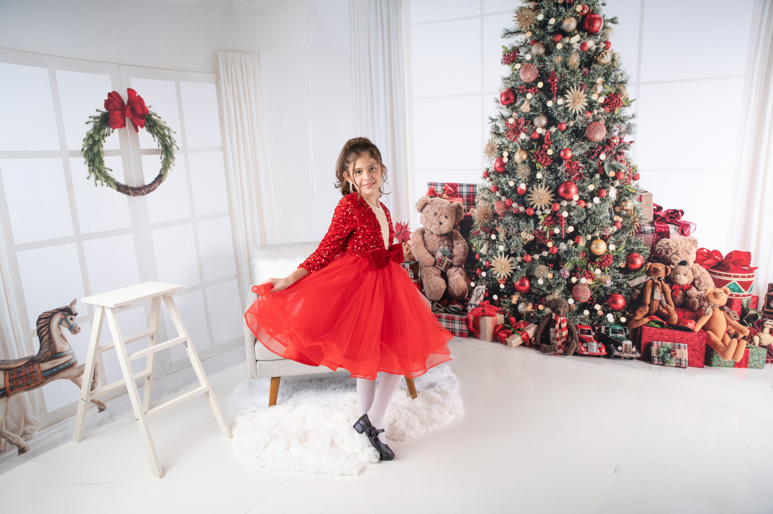 girl wearing red dress inside christmas wondeland studio
