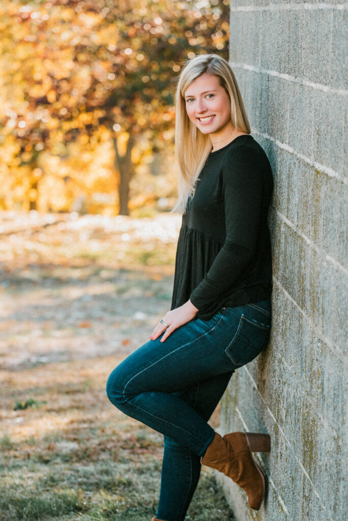 Senior portrait of a high school student surrounded by autumn trees in Fairfield County CT